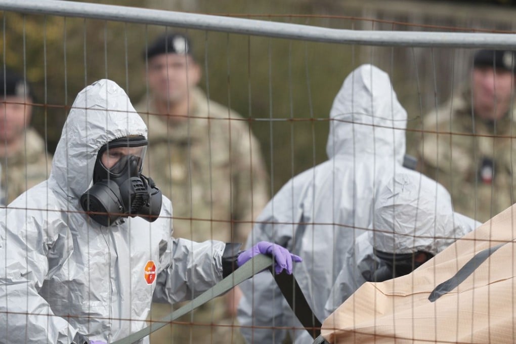 British military personnel wearing protective suits work on March 14  to remove a vehicle connected to the March 4 nerve agent attack in Salisbury, southeast England. Photo: AFP