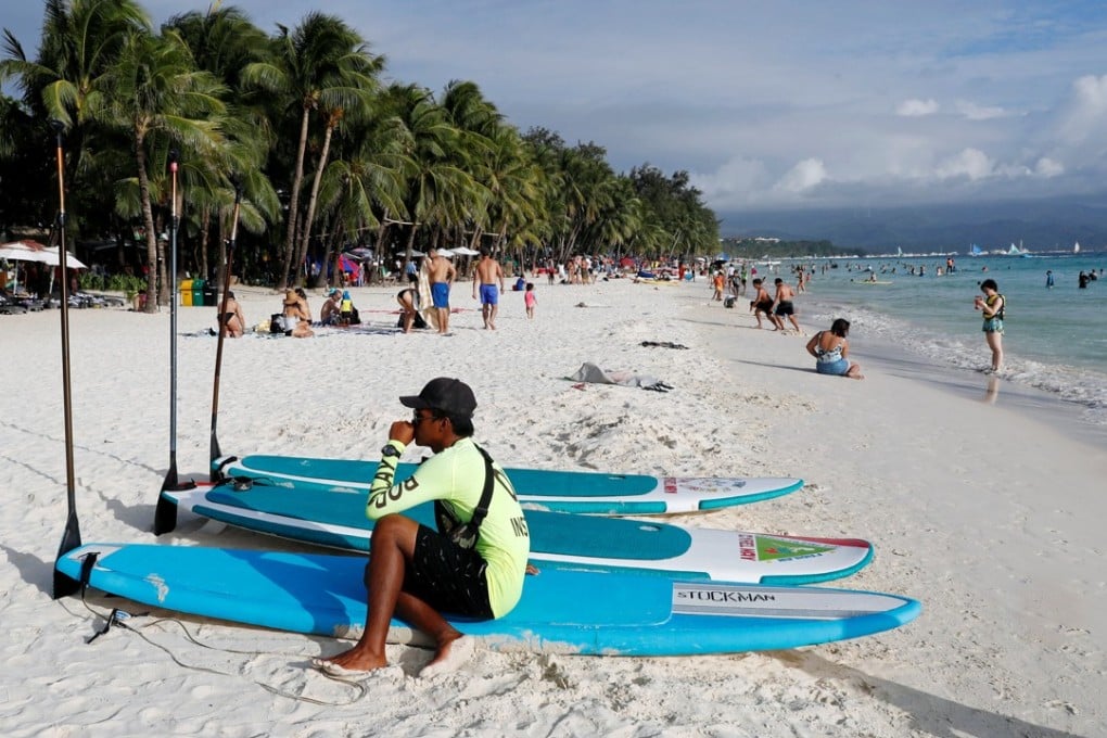 A surfing rental worker waits for customers along the beach on Boracay. Photo: Reuters