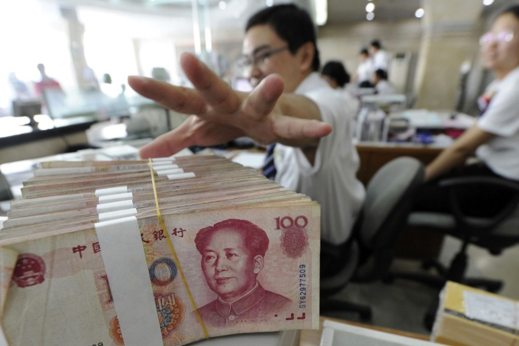 An employee reaches for a bundle of 100 yuan banknotes at a branch of Bank of China in Hefei in Anhui province on September 17, 2010. Photo: Reuters
