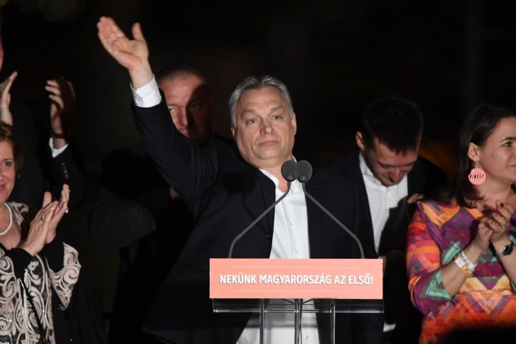 Hungarian Prime Minister Viktor Orban (centre) and members of his Fidesz party celebrate from the podium on the bank of the Danube River after winning the parliamentary election in Budapest. Photo: AFP