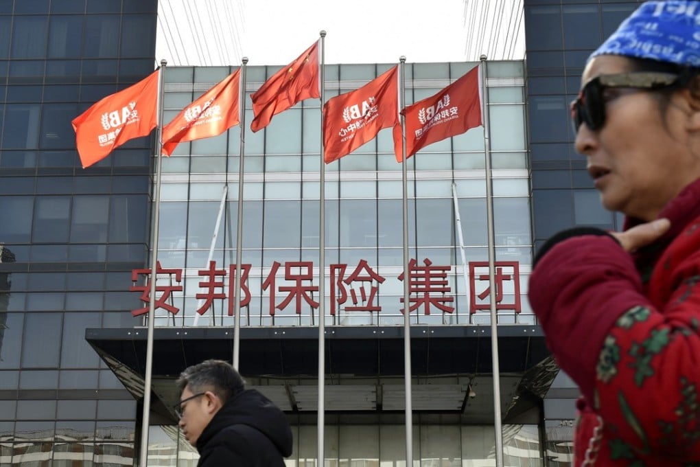 People walk past a building of Anbang Insurance Group, which will be placed under Chinese government control for one year, in Beijing. Photo: Kyodo