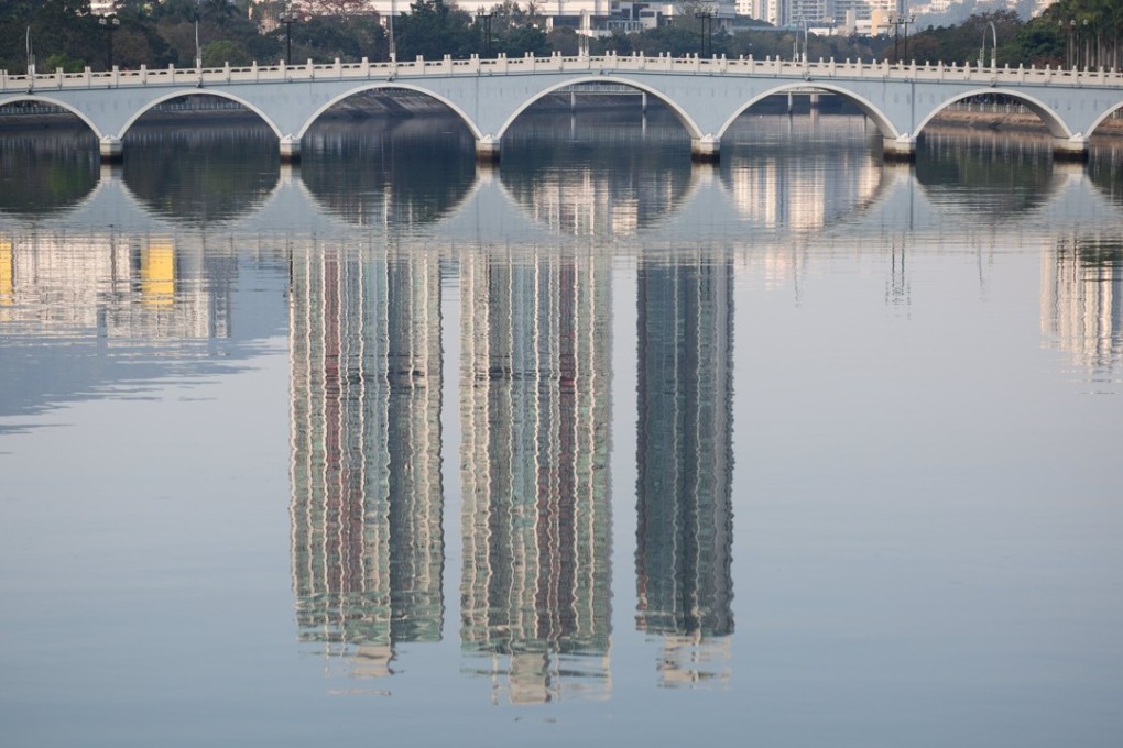 Residential buildings are reflected in the Shing Mun River in Shatin. Chinese developers are increasingly eyeing the secondary market in Hong Kong. Photo: EPA-EFE