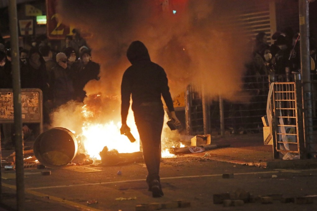 A rioter gets ready with bricks, as fires burn during clashes between protesters and police, in Mong Kok in February 2016. Hong Kong cannot rest easy in the belief that protests are always peaceful in the city. Photo: AP
