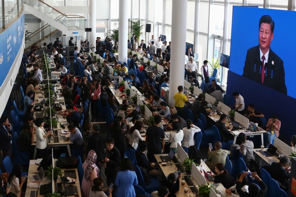 Journalists watch a screen showing Chinese President Xi Jinping as he delivers a speech during the opening of the Boao Forum for Asia in Hainan province on April 10, 2018. Photo: AFP