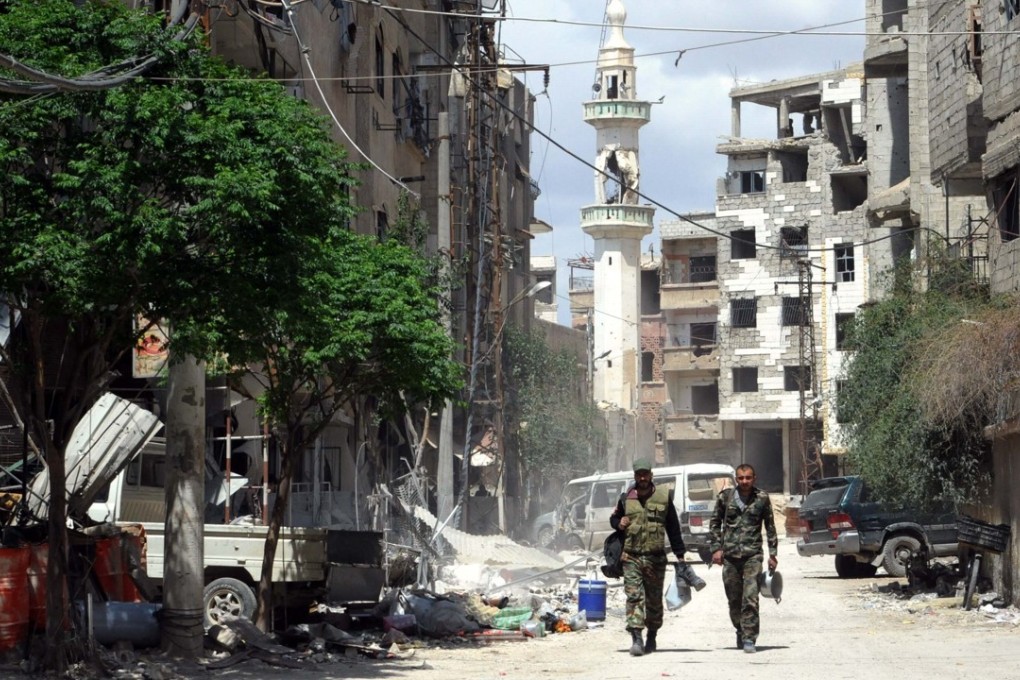 Syrian soldiers walk in the recently captured Zamalka suburb in Eastern Ghouta outside Damascus on Tuesday. US-Russia tension runs high over an alleged chemical weapons attack in Syria. Photo: Xinhua