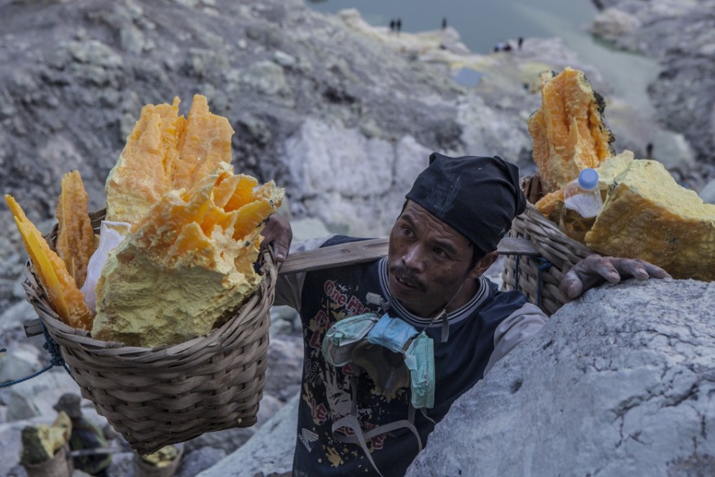 Miner carrying baskets of sulphur in Kawah Ijen, East Java, Indonesia. Photo: Agoes Rudianto