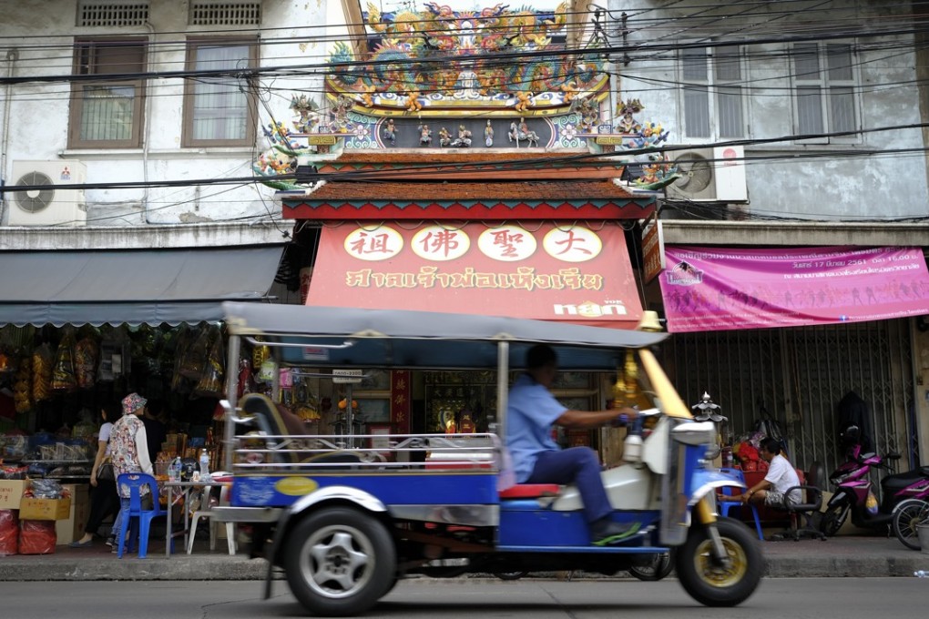 A tuk-tuk passes in front of a temple on Rama IV road in Old Chinatown, Bangkok, Thailand. Photo: James Wendlinger