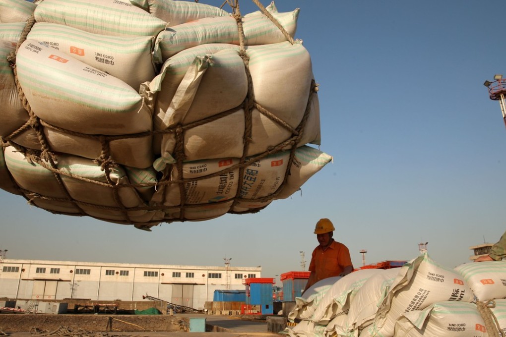 Workers transport imported soybean products at a port in Nantong, China. Photo: Reuters