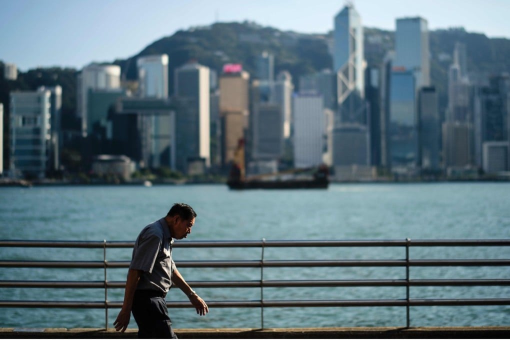 An elderly man walks along a Kowloon promenade next to Hong Kong’s Victoria Harbour. Photo: AFP