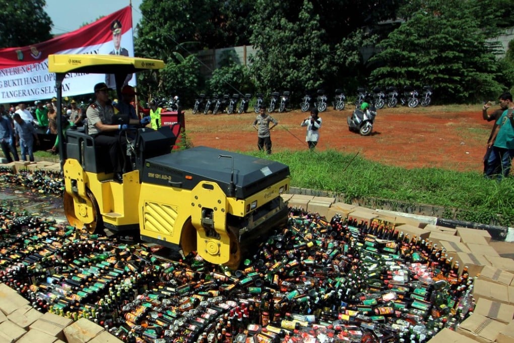 Indonesian police destroy thousands of bottles of illegal home-made alcohol. Photo: AFP