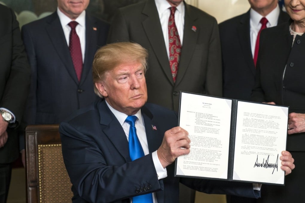 US President Donald Trump raises a presidential memorandum targeting what the White House termed ‘China's economic aggression’. Photo: EPA