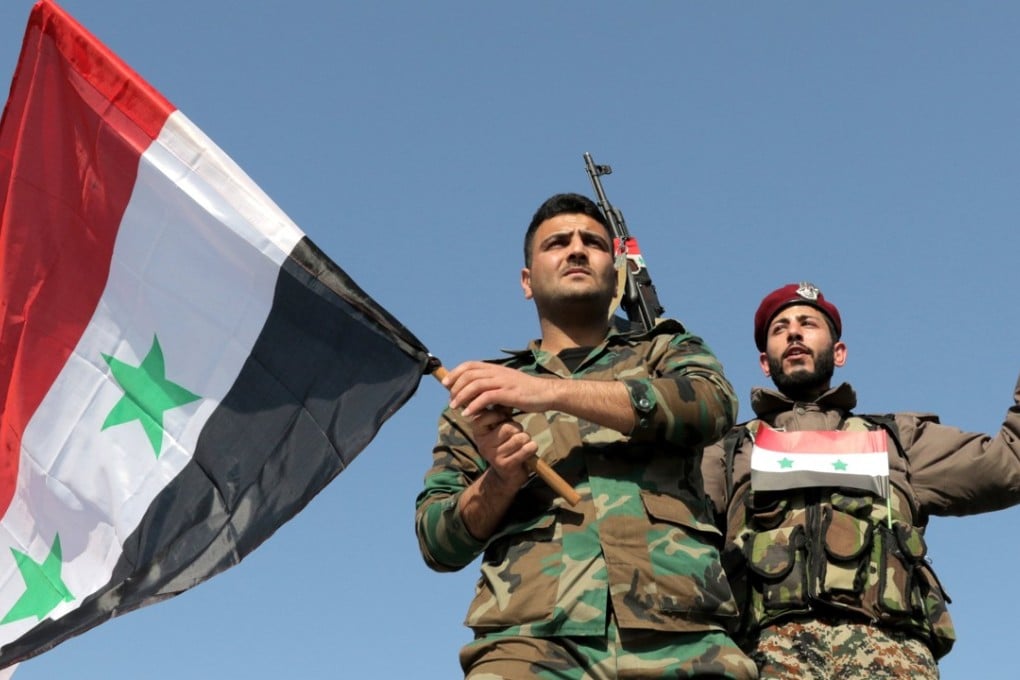 Syrian soldiers wave national flags during a gathering to show support for the Syrian government in Umayyad square in Damascus, Syria. Photo: EPA