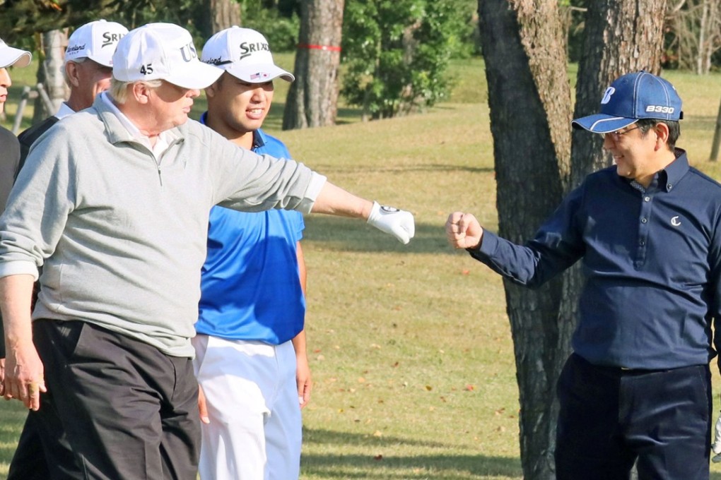 US President Donald Trump ‘fist-bumps’ Japan's Prime Minister Shinzo Abe during a round of golf in 2017. File photo: Kyodo
