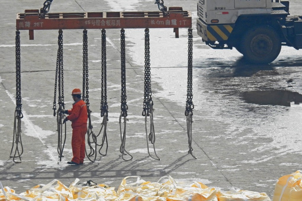 Workers pile up sacks of soda ash to be exported at a port in Lianyungang in Jiangsu province on April 13, 2018. Photo: China Daily via REUTERS