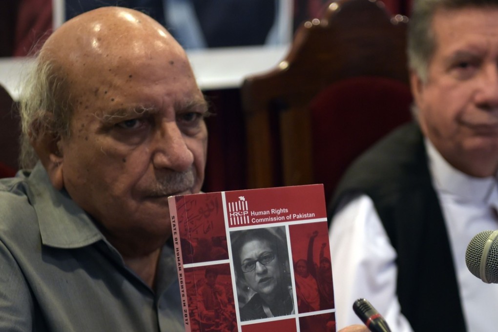 I.A. Rehman, spokesman for the Human Rights Commission of Pakistan (HRCP), displays a copy of the State of Human Rights report in Islamabad. Photo: AFP