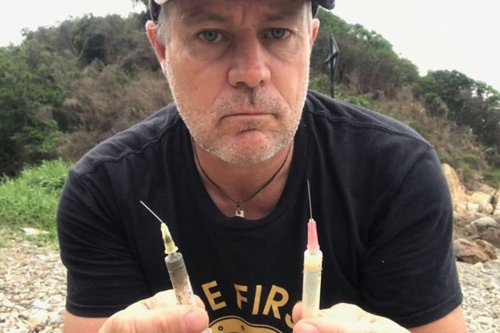 Beach clean-up organiser Robert Lockyer with syringes found at Pak Kok Tsui, Lamma Island.