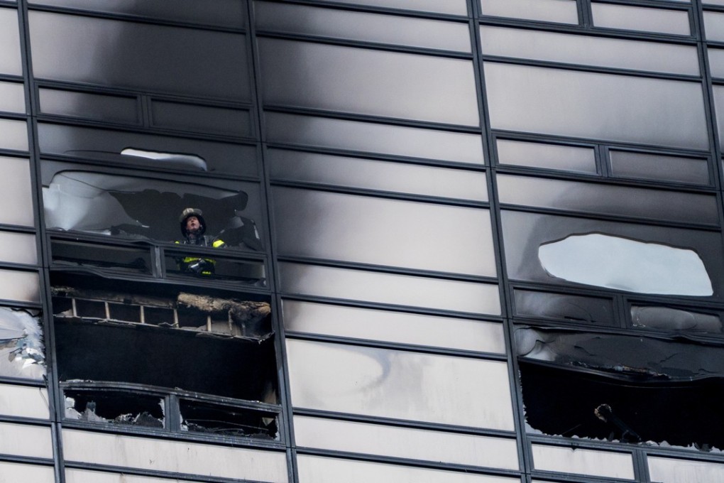 A firefighter looks out from the window of a damaged apartment in Trump Tower in New York on April 7. Photo: AP