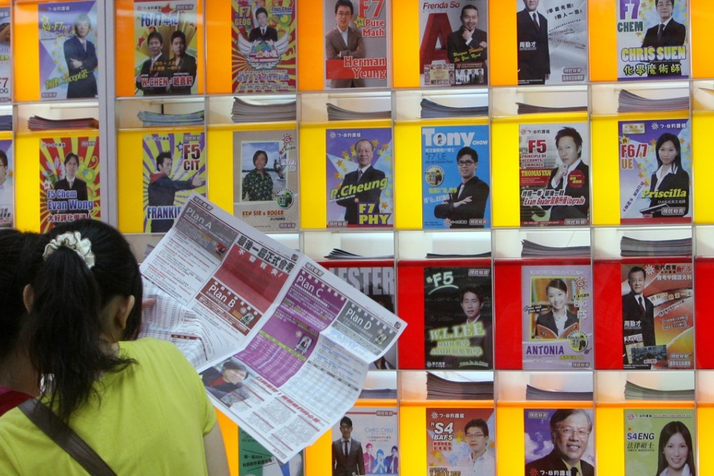 Young pupils take a look at the line-up of tutors and newspaper ads, at a tutorial school in Hong Kong. Photo: K.Y. Cheng