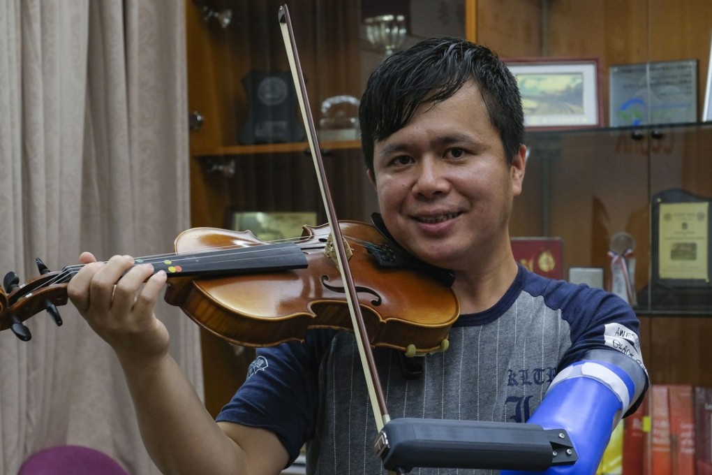 Shum plays the violin using his new artificial arm at the Chinese University of Hong Kong in Sha Tin. Photo: Tory Ho