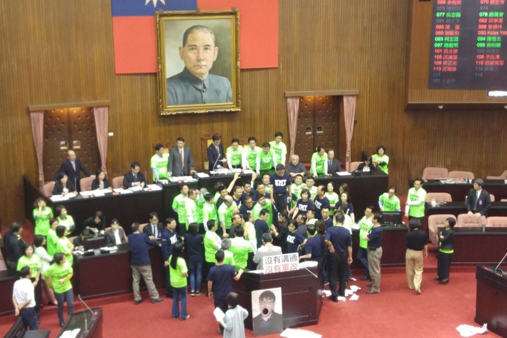 Taiwanese legislators arguing on Friday on the floor of the parliamentary chamber, with stewards trying to restore order. Photo: CNA