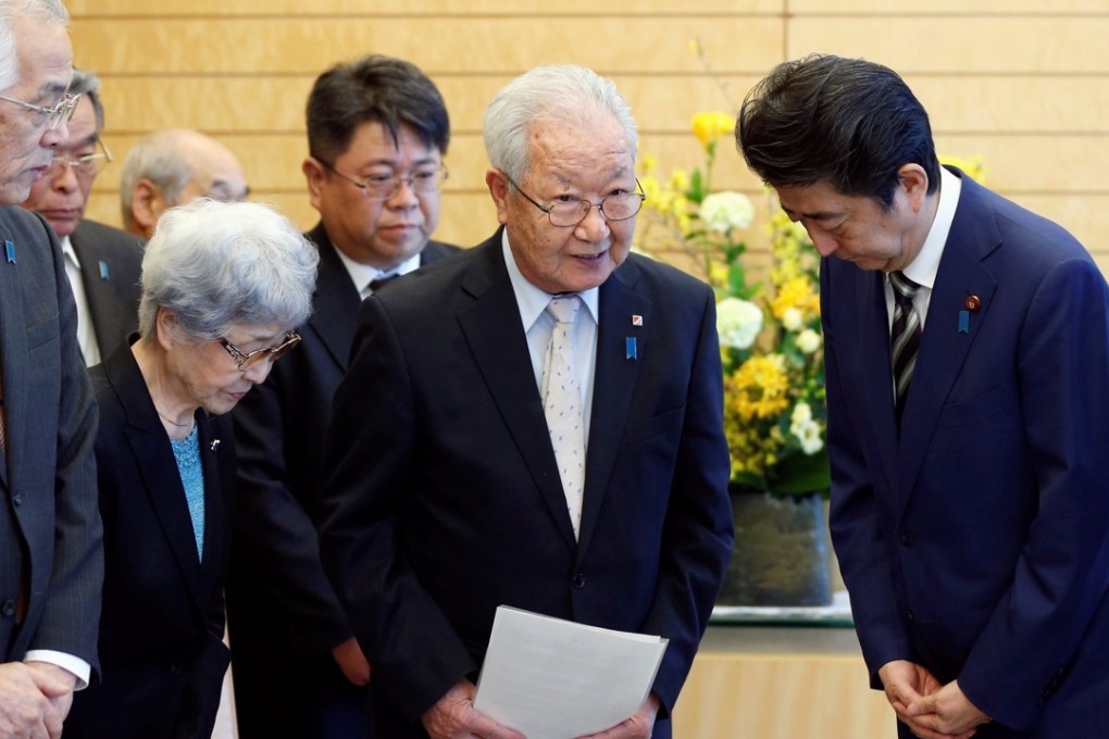 Japanese Prime Minister Shinzo Abe, right, meets Shigeo Iizuka, the leader of a group of families whose relatives were abducted by North Korea. Photo: Reuters