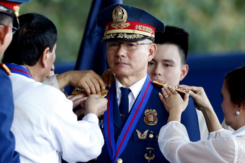 New chief of the Philippine National Police Director-General Oscar Albayalde receives his four-star rank from Philippine President Rodrigo Duterte. Photo: AP
