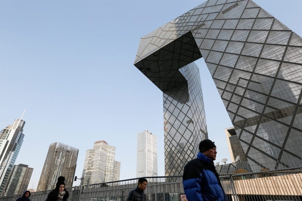 People walk past the China Central Television (CCTV) headquarters in downtown Beijing, which Chinese people say resembles a pair of trousers. Photo: EPA