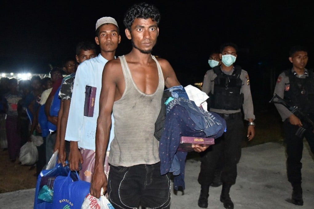 Rohingya men line up to enter a temporary shelter in Bireuen, Aceh province, Indonesia, after drifting on a boat for days. Photo: AP