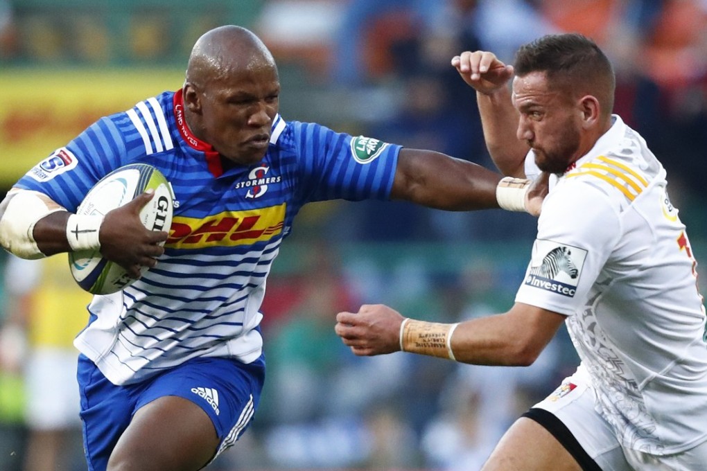 Bongi Mbonambi (left) from the Stormers hands off Aaron Cruden from the Chiefs. Photo: EPA