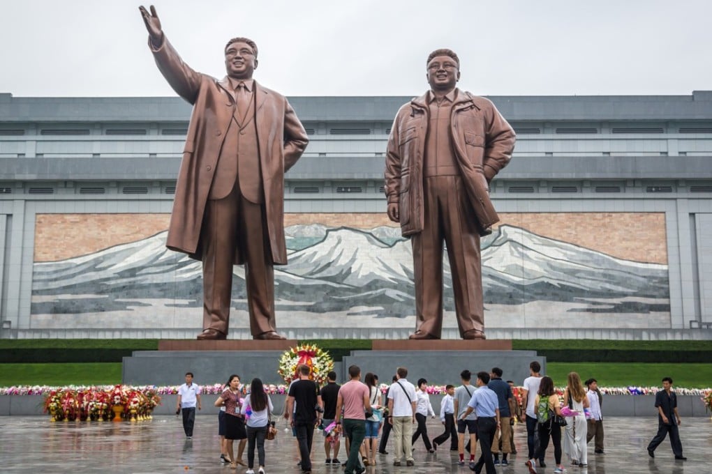 Locals and tourists in front of bronze statues of former North Korean leaders Kim Il-sung and Kim Jong-il at the Grand Monument on Mansu Hill in Pyongyang, North Korea.