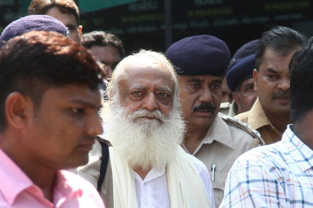 In this file photo taken on October 15, 2013 Indian spiritual guru Asaram Bapu (centre) is escorted by state police as he leaves a local court in Gandhinagar, some 30km from Ahmadabad. Photo: Agence France-Presse