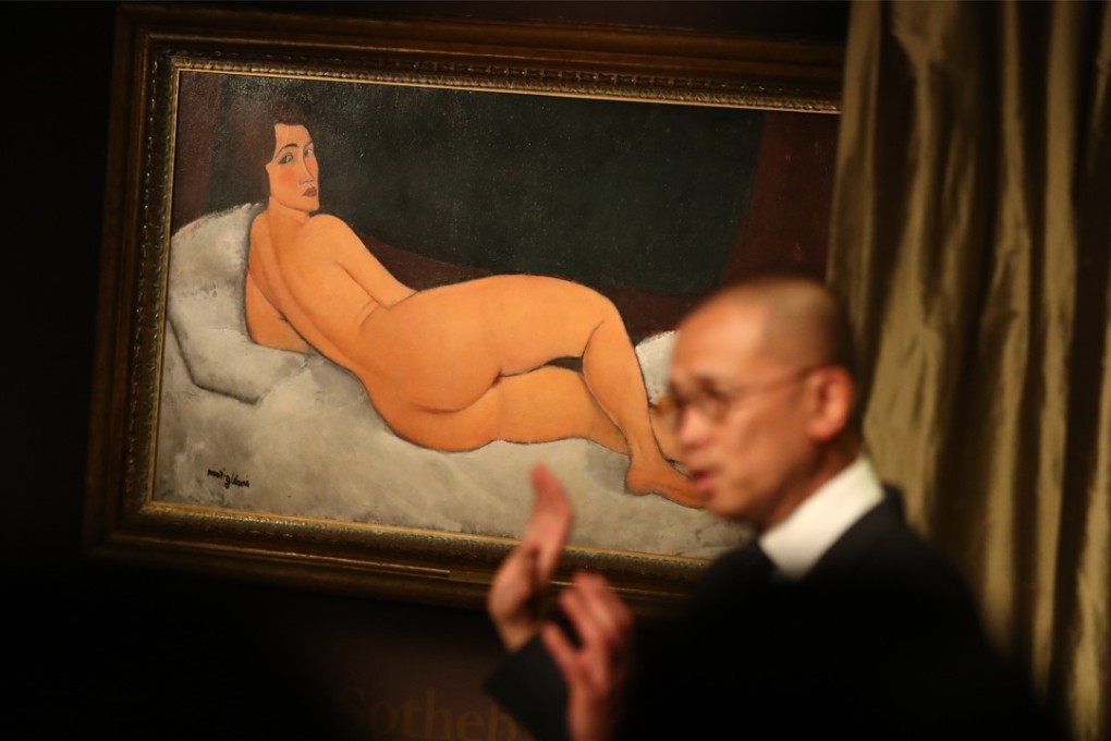 Chief executive of Sotheby’s Hong Kong Kevin Ching unveils Nu Couche (sur le côté gauche), a 1917 painting by 20th-century Italian painter Amedeo Modigliani, ahead of its auction in New York on May 14. Photo: Nora Tam
