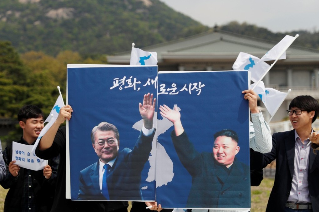 Students hold posters with pictures of Moon Jae-in and Kim Jong-un during a pro-unification rally in Seoul on Thursday. Photo: Reuters