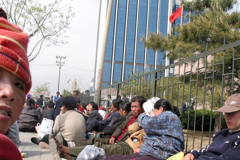 A group of Chinese farmers stage a sit-in protest outside the headquarters of the Beijing People's Congress, in Beijing, demanding compensation for land the government repossessed for development. Picture: AFP