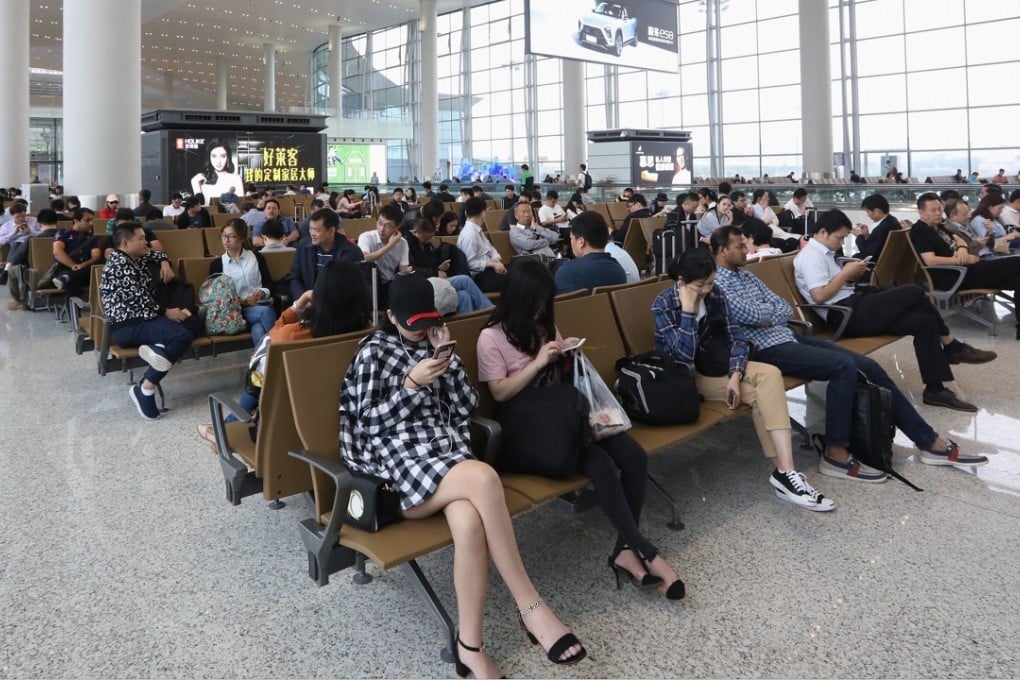 Travellers wait at the new Guangzhou airport terminal on its first day of operation on Thursday. Photo: Edward Wong