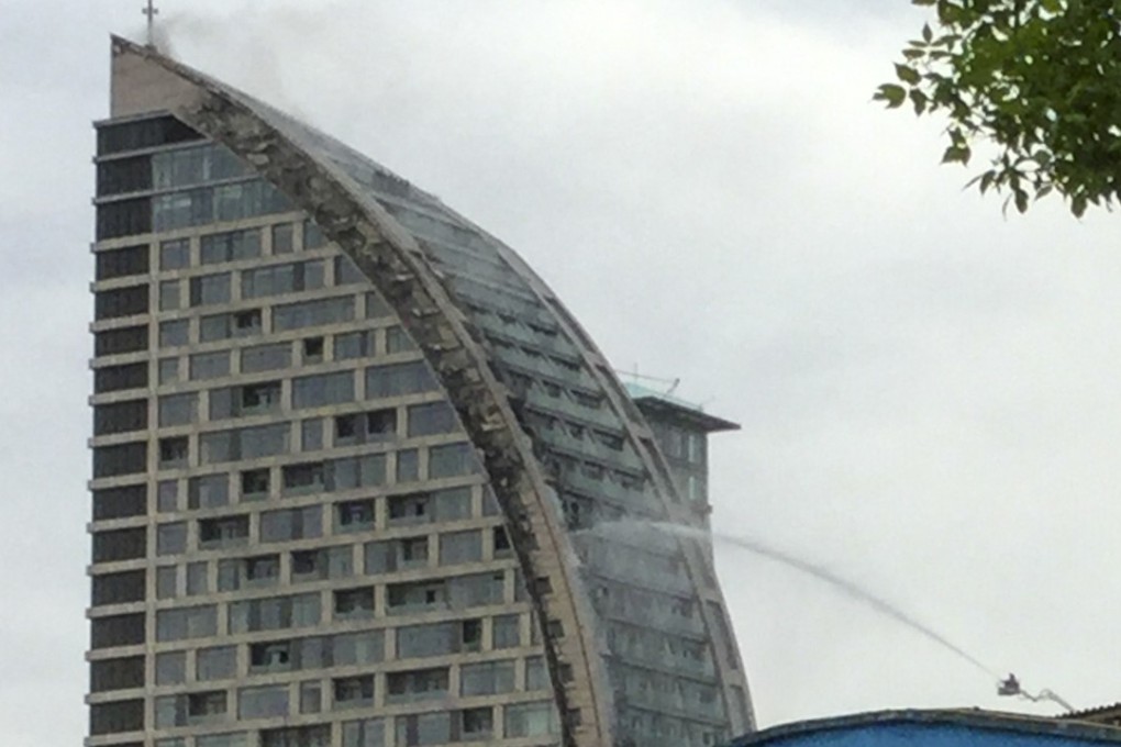 Azerbaijani firefighters spray water on the Trump-branded building in Baku, Azerbaijan. Photo: AP