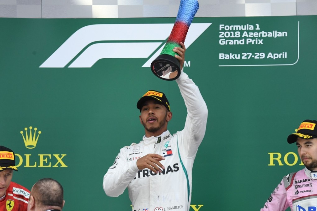 Mercedes' British driver Lewis Hamilton (centre) celebrates next to second placed Kimi Raikkonen (left) and third placed Force India's Sergio Perez. Photo: AFP
