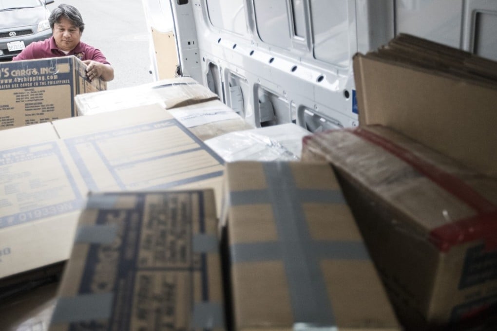 Balikbayan box shipper Norbil Caburog loads a box into his truck for customers shipping to family in the Philippines while on his route in Carson, Calif., on April 7, 2018. (Brian van der Brug/Los Angeles Times/TNS)