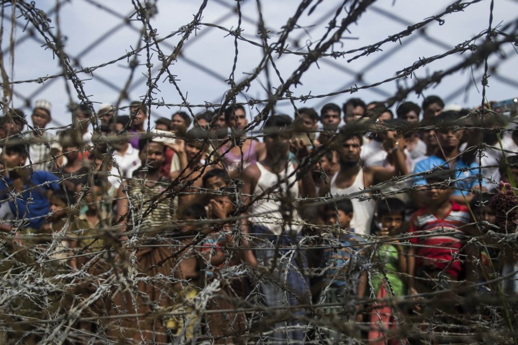 Rohingya refugees are seen behind a barbed-wire fence in a temporary settlement in a ‘no man’s land’ border zone between Myanmar and Bangladesh. Photo: AFP