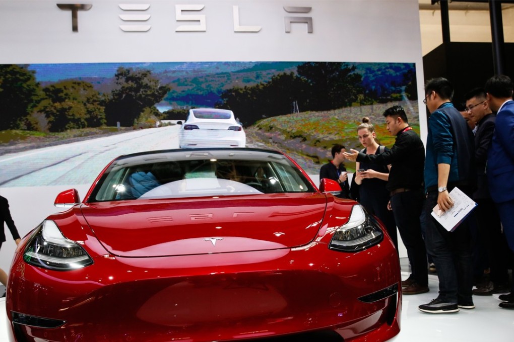 Visitors look at Tesla Model 3 car during Auto China 2018 motor show in Beijing, China, 25 April 2018. Photo: EPA-EFE