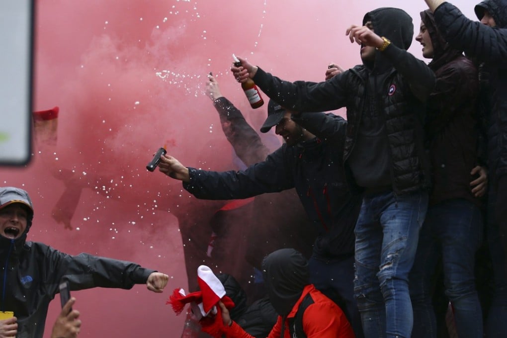 Fans stand on a police van outside Anfield before Liverpool’s match against Roma on April 24. Photo: AP
