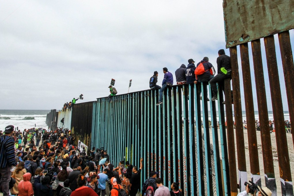 Central American migrants arrive at the wall in the US-Mexico border, at Tijuana, Mexico, on Sunday. Photo: EPA