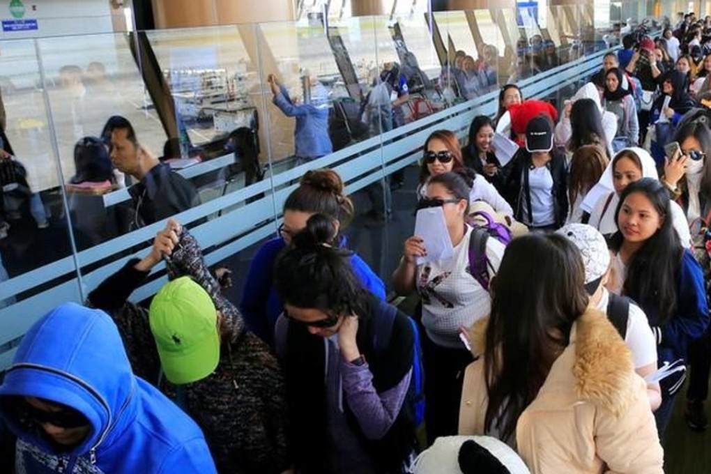 Workers from the Philippines arrive at the Ninoy Aquino International Airport after returning from Kuwait. Photo: Reuters