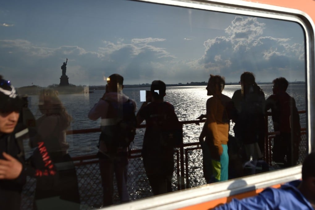 People ride the Staten Island ferry while passing the Statue of Liberty, in New York City. US GDP expanded by 2.3 per cent in the first quarter of 2018, healthily above the 2 per cent rise that economists had forecast. Photo: AFP