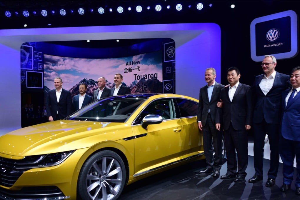 Herbert Diess, CEO of Volkswagen (4th R) poses with officials and the next generation Volkswagen CC 380 TSI car during its launch at the Beijing Auto Show on April 25, 2018. AFP PHOTO