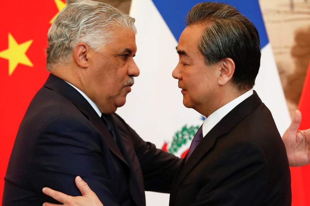 China's State Councillor and Foreign Minister Wang Yi (right) hugs the Dominican Republic's Chancellor Miguel Vargas during a signing ceremony in Beijing. Photo: Reuters
