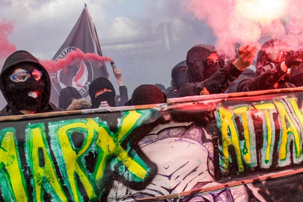 Masked protesters with banners and placards block a road ahead of clashes with French police forces during the annual May Day marches in Paris on Tuesday. Photo: EPA-EFE