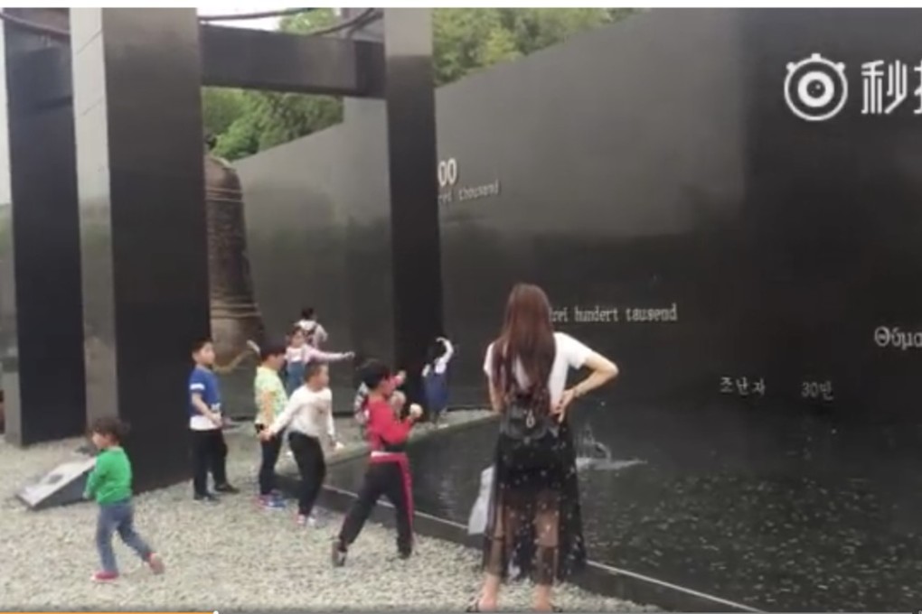 The children filmed throwing small pebbles at the memorial. Photo: SCMP Pictures