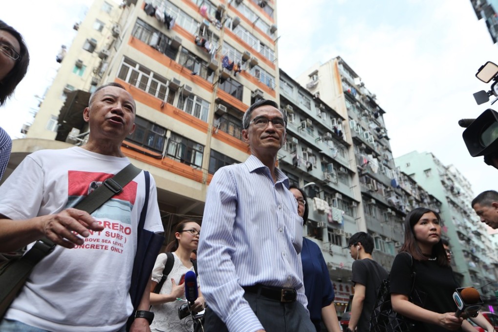 Stanley Wong (centre), chairman of the task force on land supply, and Ho Hei-wah (second from left), director of the Society for Community Organisation, visit subdivided flats in Sham Shui Po in late April. Photo: Winson Wong