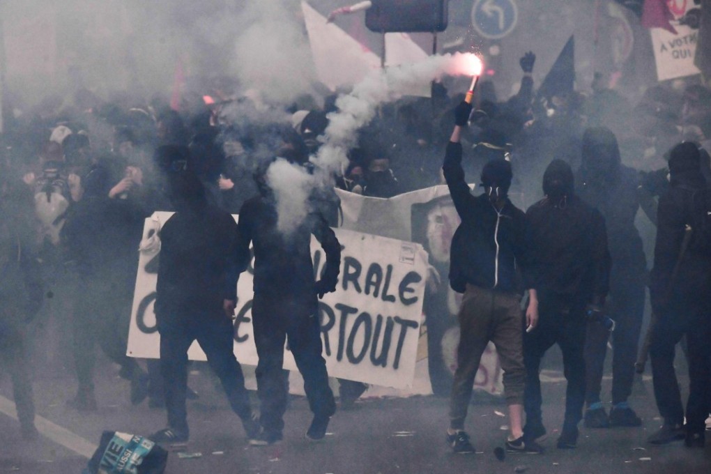 A protester lights a flare during a demonstration near the annual May Day workers’ rally in Paris. Photo: AFP